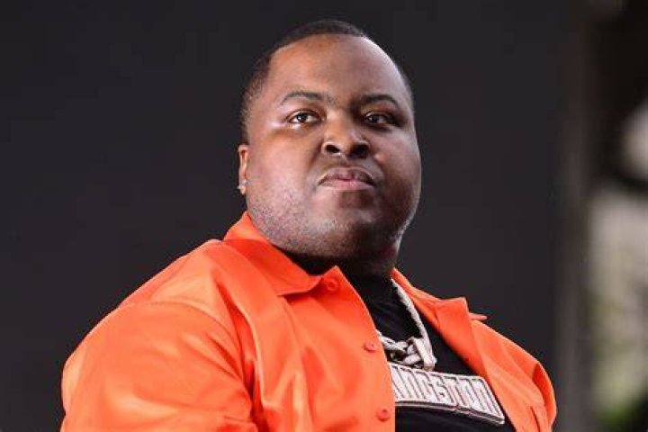 Sean Kingston is making a peace sign on the red carpet.